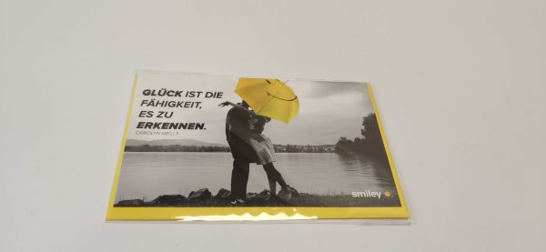 Allgemeine Wünsche – Smiley - Glückwunschkarte im Format 8,5 cm x 13,5 cm mit Umschlag – umarmendes Paar am See mit Smileyregenschirm